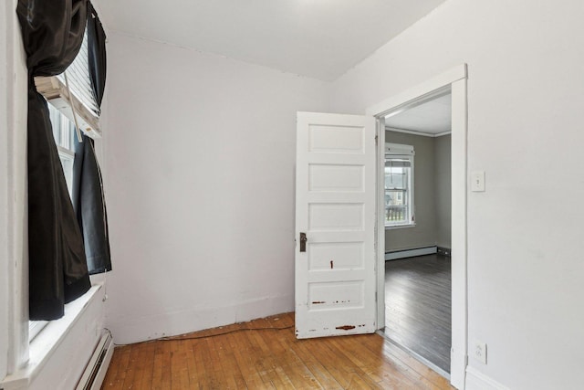 unfurnished room featuring light wood finished floors, a baseboard radiator, and baseboard heating