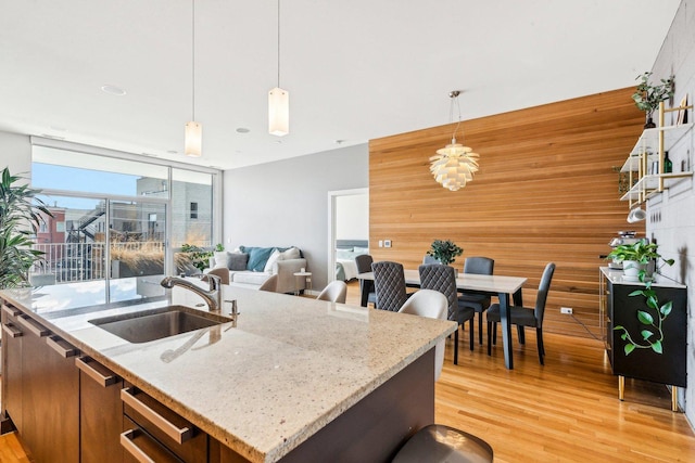 kitchen with light wood-style floors, hanging light fixtures, and a sink
