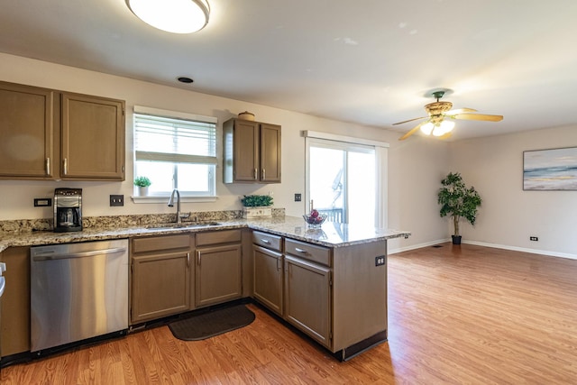 kitchen with dishwasher, a sink, a peninsula, light wood finished floors, and a ceiling fan