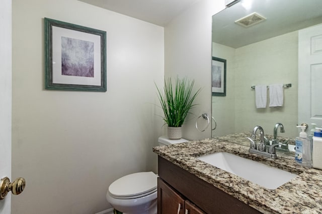 half bathroom featuring toilet and vanity