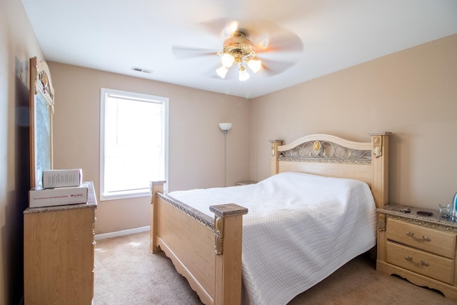 bedroom with light colored carpet, a ceiling fan, and baseboards