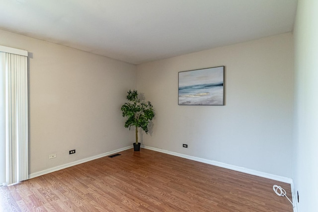 spare room featuring wood finished floors and baseboards