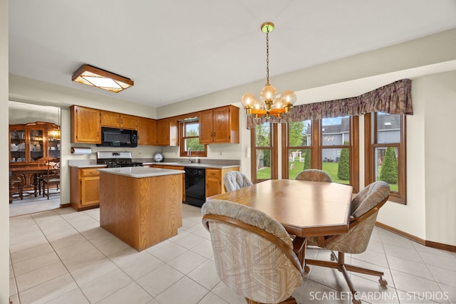 221 Ashley Ct, Oswego, IL 60543 - kitchen featuring black appliances, a sink, a chandelier, light countertops, and a kitchen island