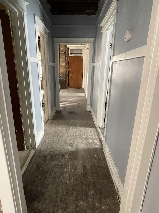 corridor with a decorative wall and a wainscoted wall