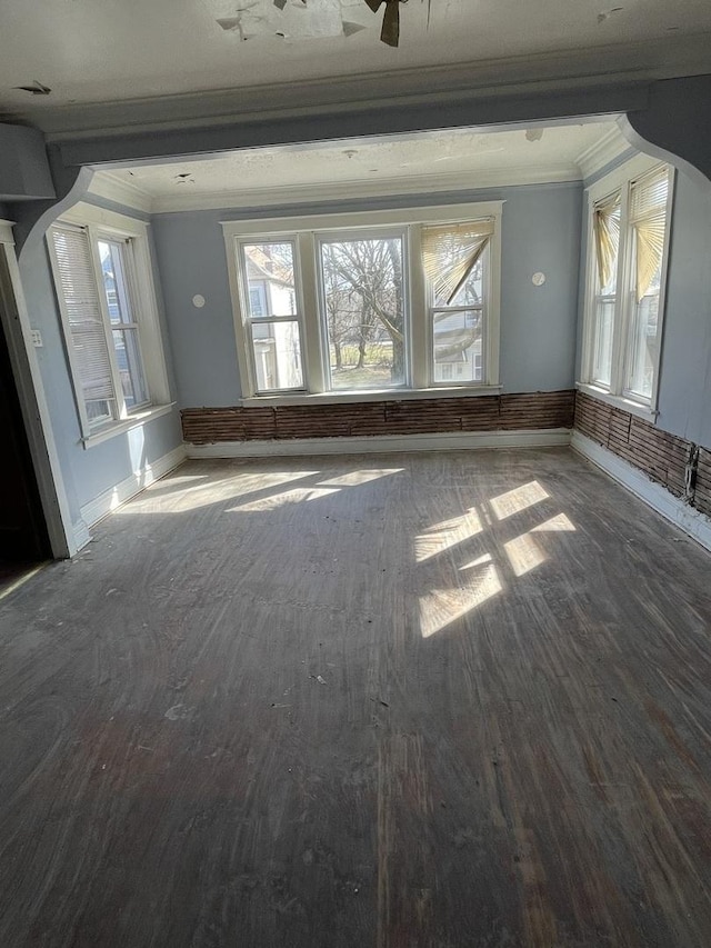 unfurnished room featuring plenty of natural light, baseboards, and ornamental molding