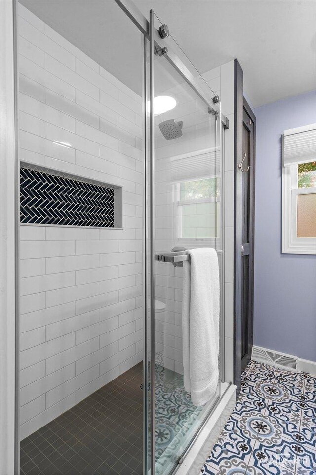 full bathroom with tile patterned floors, visible vents, baseboards, and a stall shower
