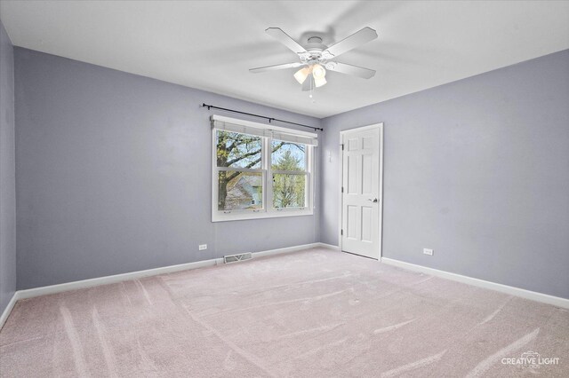 empty room with ceiling fan, visible vents, baseboards, and carpet