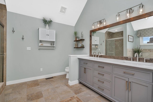bathroom featuring a stall shower, toilet, lofted ceiling, and a sink
