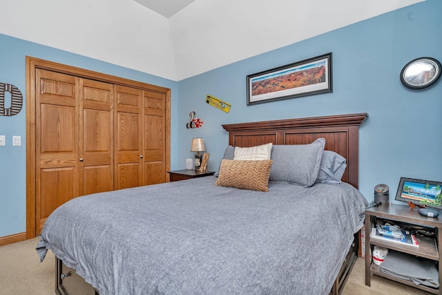 bedroom featuring lofted ceiling, a closet, and light colored carpet