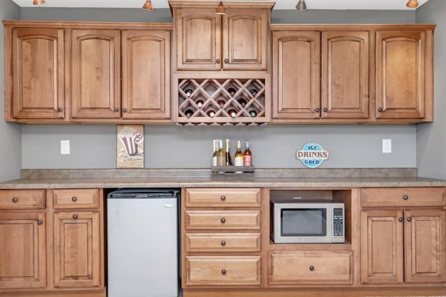 interior space with stainless steel microwave, freestanding refrigerator, and light countertops