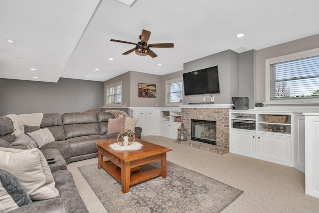 carpeted living area with a ceiling fan, recessed lighting, and a brick fireplace