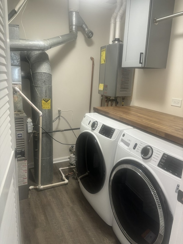 laundry room featuring tankless water heater, cabinet space, dark wood-style flooring, and washer and clothes dryer