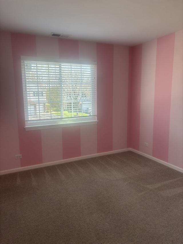 spare room with visible vents, carpet floors, and baseboards