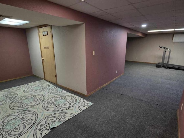 finished basement with a paneled ceiling, baseboards, visible vents, and carpet