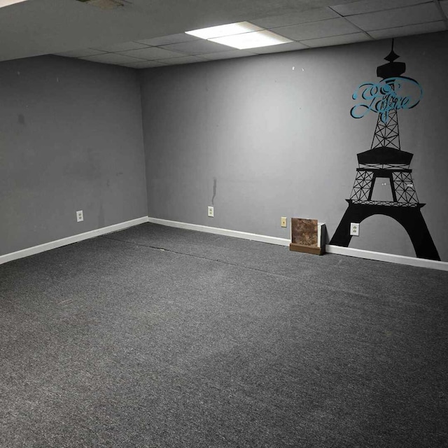 interior space featuring a paneled ceiling, baseboards, and dark colored carpet
