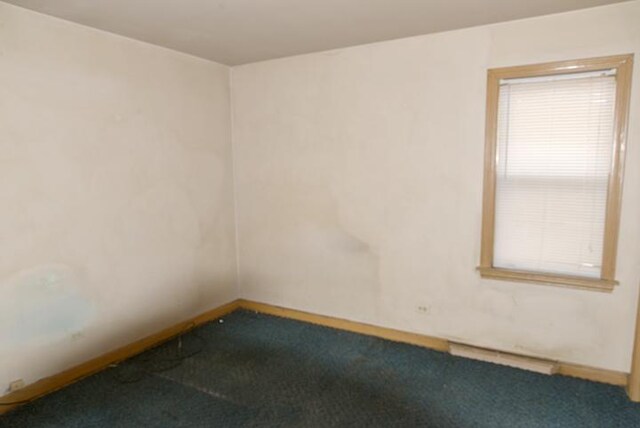 carpeted spare room with baseboards