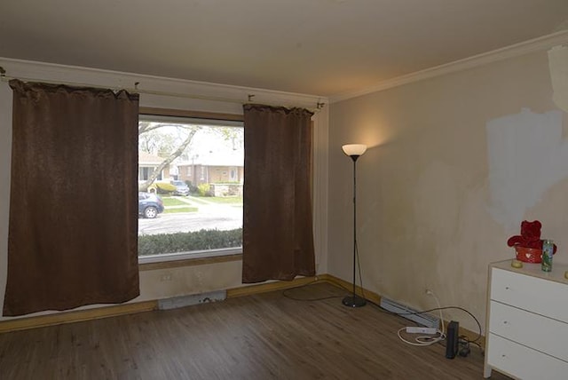 unfurnished room featuring ornamental molding, wood finished floors, and baseboards