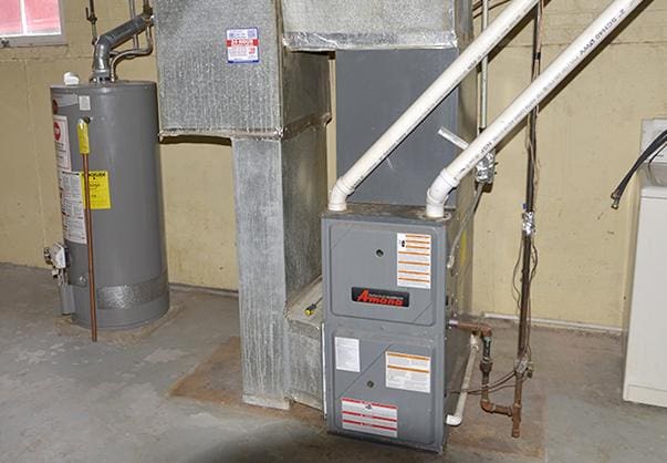 utility room featuring water heater and heating unit
