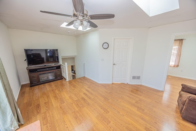 1315 Dellmar Ave, Joliet, IL 60435 - unfurnished living room with visible vents, baseboards, ceiling fan, light wood-style flooring, and a skylight