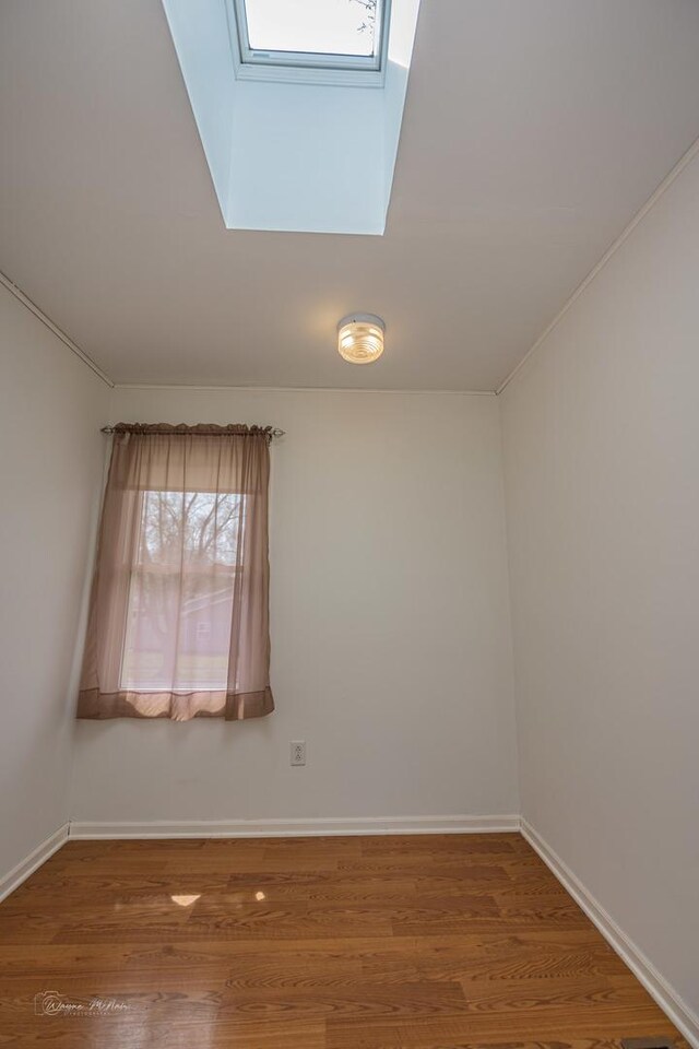 1315 Dellmar Ave, Joliet, IL 60435 - spare room with baseboards, wood finished floors, and a skylight