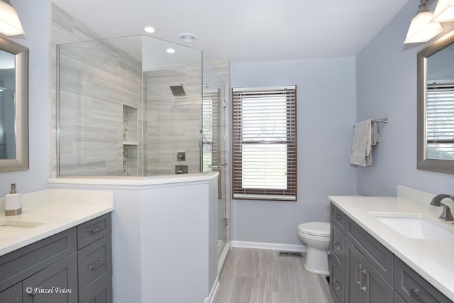 bathroom featuring two vanities, a stall shower, and a sink