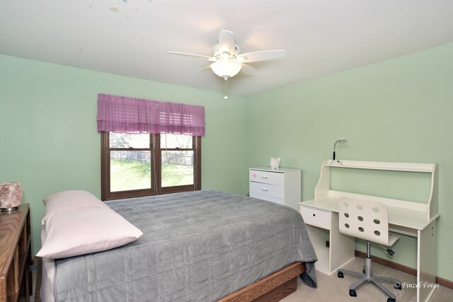 carpeted bedroom with ceiling fan and baseboards