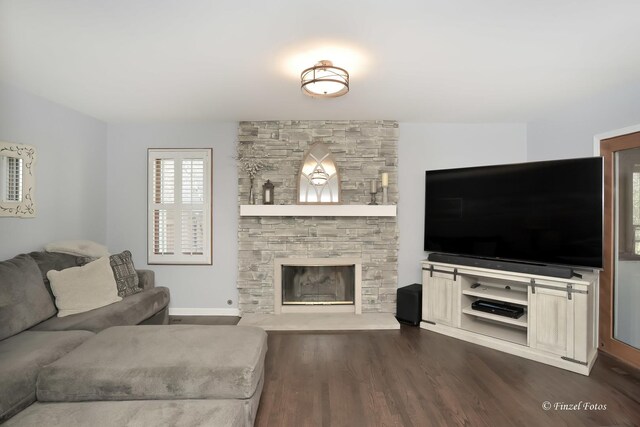 living area featuring baseboards, dark wood-style flooring, and a fireplace