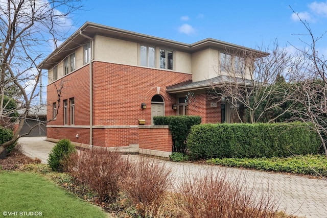 view of front of property with brick siding and stucco siding