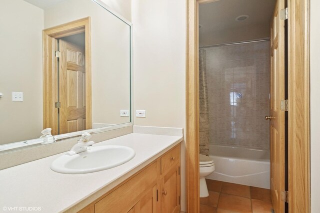 full bath featuring shower / bath combo with shower curtain, toilet, vanity, and tile patterned floors