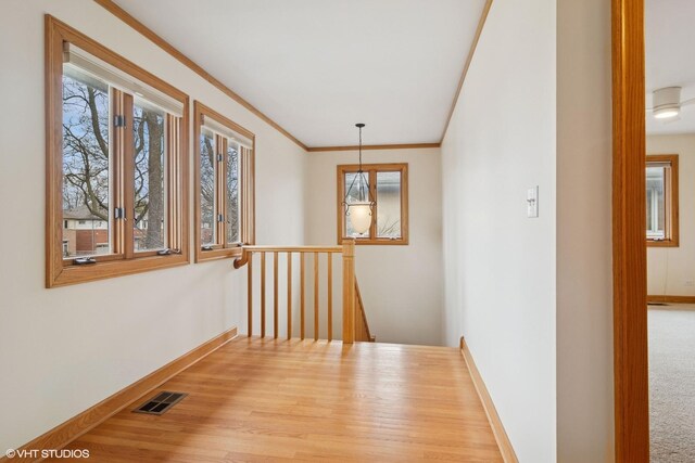 corridor with plenty of natural light, baseboards, and visible vents