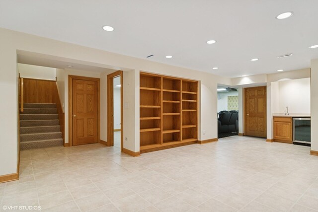 unfurnished living room with recessed lighting, baseboards, built in features, and stairs