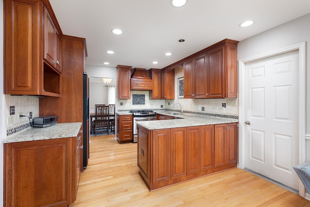 925 Appomattox Cir, Naperville, IL 60540 - kitchen featuring gas stove, light wood-style floors, a peninsula, custom range hood, and tasteful backsplash