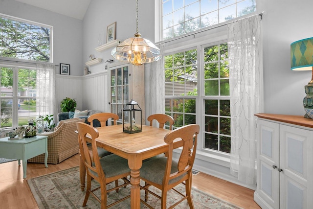 3 Spring Garden Ct, Lake In The Hills, IL 60156 - dining room featuring a chandelier, high vaulted ceiling, light wood finished floors, and a wainscoted wall