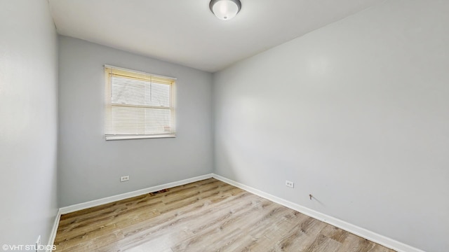 unfurnished room featuring baseboards and light wood finished floors