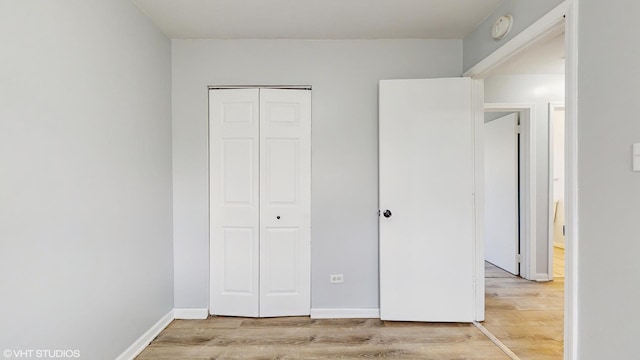 unfurnished bedroom featuring light wood finished floors and a closet