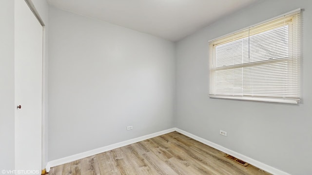 unfurnished room featuring visible vents, baseboards, and light wood-type flooring