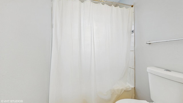 full bath featuring toilet and a shower with curtain