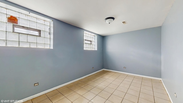spare room featuring baseboards, visible vents, and light tile patterned floors