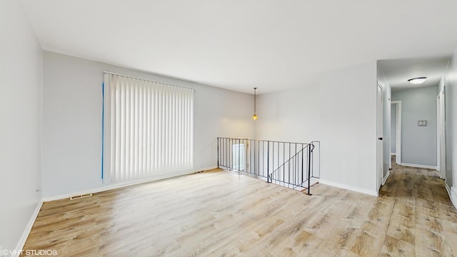 spare room with visible vents, wood finished floors, and baseboards