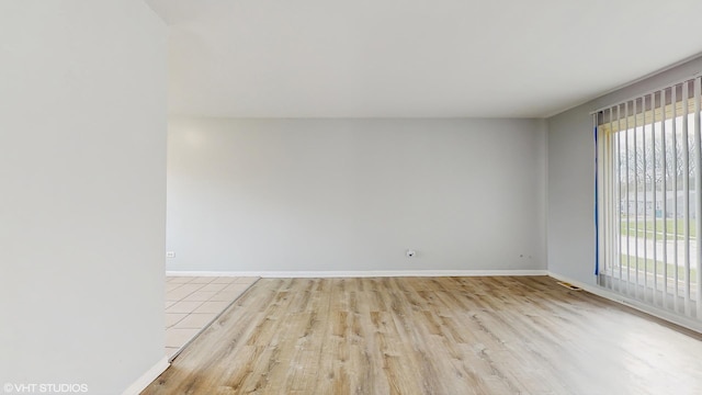 empty room featuring wood finished floors and baseboards