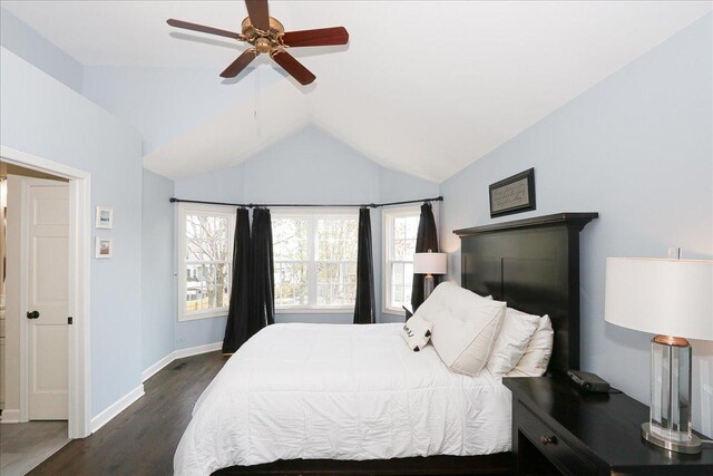 bedroom featuring baseboards, ceiling fan, dark wood-style floors, and vaulted ceiling