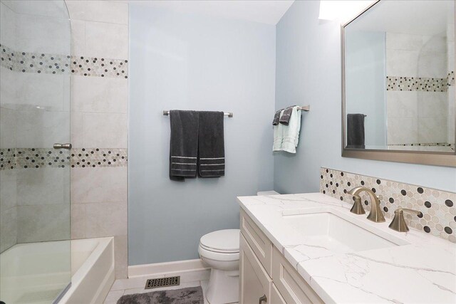 full bath with visible vents, vanity, baseboards, toilet, and washtub / shower combination
