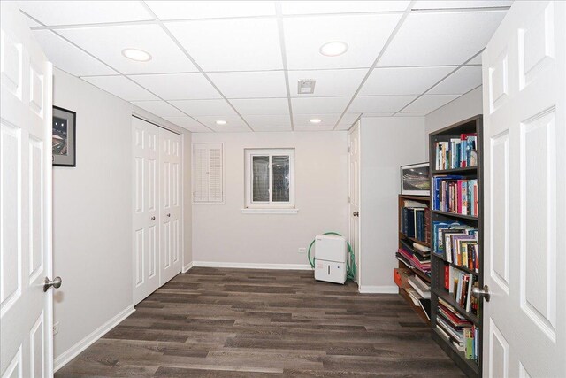 interior space featuring baseboards, recessed lighting, dark wood-style flooring, and a paneled ceiling