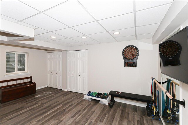 interior space featuring baseboards, a drop ceiling, recessed lighting, and wood finished floors