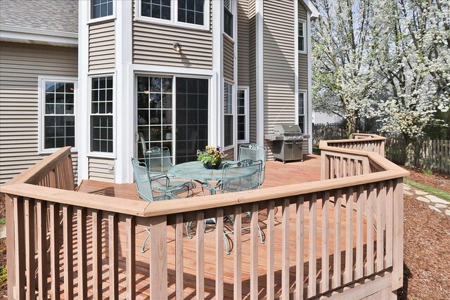 deck featuring outdoor dining area and a grill