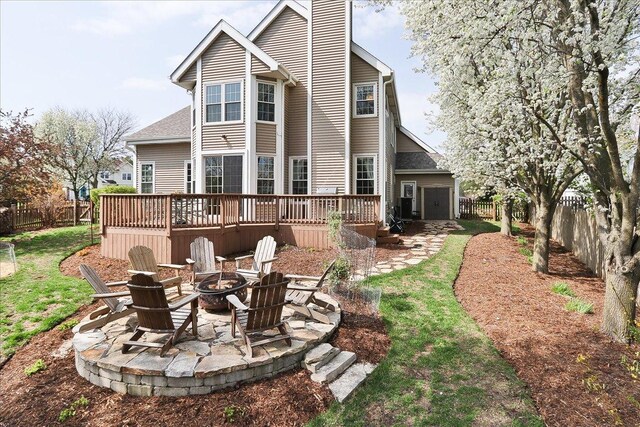 rear view of property featuring a deck, a fenced backyard, a chimney, a patio area, and a fire pit