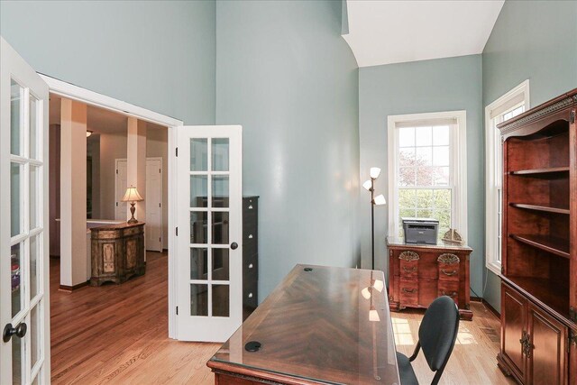 home office featuring french doors and light wood-style floors