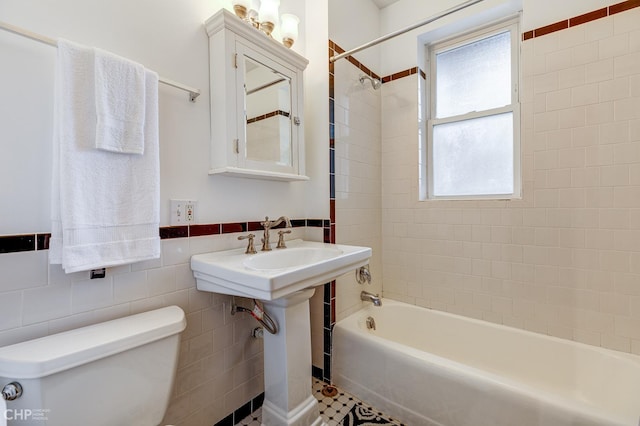 1949 W Argyle St Unit 1, Chicago, IL 60640 - bathroom featuring tile walls, shower / bathtub combination, and wainscoting