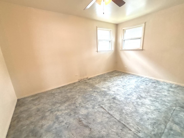 carpeted spare room with ceiling fan and baseboards