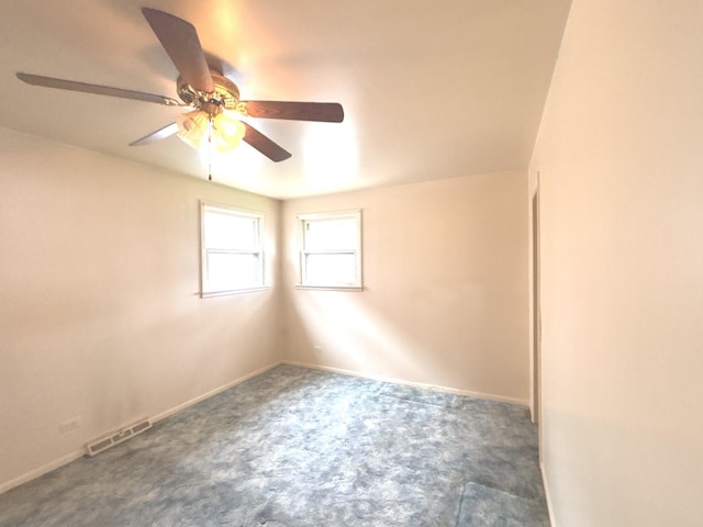 carpeted empty room featuring a ceiling fan and baseboards